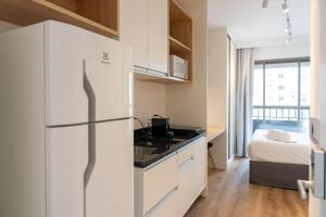 a kitchen with a refrigerator and a bed in a room at Studio Completo Consolação - Metro Higienopolis-Mackenzie in Sao Paulo