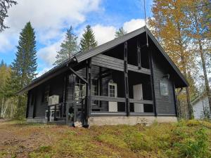 una casa negra en una colina en el bosque en Syötekätkö, en Syöte