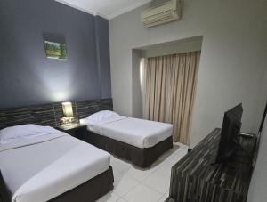 Postel nebo postele na pokoji v ubytování N2 Hotel Gunung Sahari