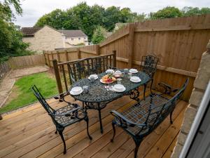 a table with four chairs on a wooden deck at 3 Bedroom family home Parking Garden - Pass the Keys in Stroud +23 photos
