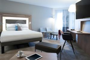 a hotel room with a bed and a desk at Novotel Château de Versailles in Versailles +75 photos