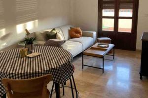 a living room with a couch and a table at Ático Santa Lucía Terraza y Parking gratuitos in Alcalá de Guadaira