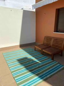 a rug on the floor in a room with a bench at Ático Santa Lucía Terraza y Parking gratuitos in Alcalá de Guadaira