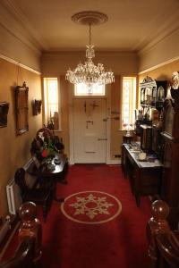 a living room with a chandelier and a red carpet at Roscaoin House in Westport