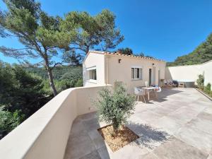a white house with a patio and a tree at L'Amorosa Suite avec terrasse et Jacuzzi extérieur in Peypin