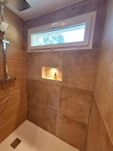 a bathroom with a shower with a window at L'Amorosa Suite avec terrasse et Jacuzzi extérieur in Peypin +43 photos