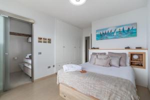 a white bedroom with a bed and a mirror at El Balcón de Abora in Los Cancajos +47 photos