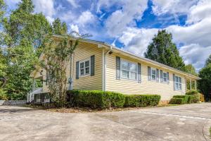 a yellow house with bushes in front of a driveway at Bearskin Getaway, Hot Tub, Free Attraction Tickets, WIFI!!! in Sevierville