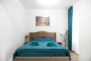 a bedroom with a bed with two green towels on it at WHITE PLATAN apartment in Iaşi