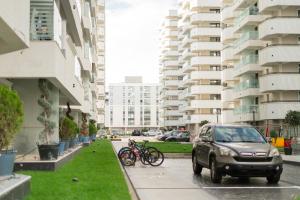 a car parked on a street with bikes parked next to buildings at WHITE PLATAN apartment in Iaşi