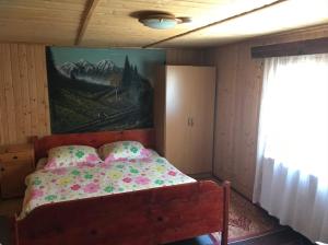 a bedroom with a bed with a painting on the wall at Casa Matei in Poarta