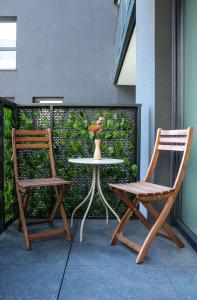 two chairs and a table with a vase on a patio at Retro Night - Apartment - Jezioro Malta in Poznań