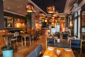 a restaurant with wooden tables and chairs and lights at Grand Daddy Boutique Hotel in Cape Town