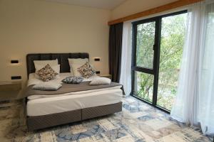 Un dormitorio con una cama y una ventana grande. en Grig House Eco Resort, en Gyulagarak