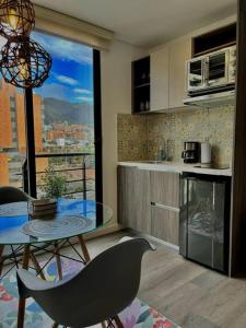 une cuisine avec une table en verre et une vue sur une ville dans l'établissement Luxury loft en el Parque Virrey, à Bogotá