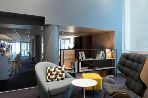 an office with chairs and a table and a couch at Novotel Château de Versailles in Versailles