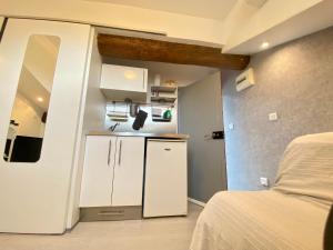 mały pokój z łóżkiem i małą kuchnią w obiekcie Mini Studio - Le Chabaud - Cannes centre w Cannes