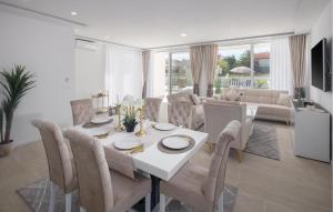 Un comedor y una sala de estar con mesa y sillas. en Lovely Home In Vrvari With Sauna, en Poreč