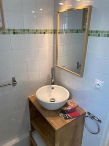 a bathroom with a white sink and a mirror at Charming Apartment Gacé II 4P in Gacé