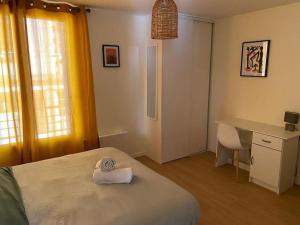 a bedroom with a bed and a desk and a chair at Charming Apartment Gacé II 4P in Gacé