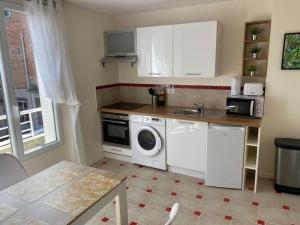 a kitchen with a washing machine and a sink at Charming Apartment Gacé II 4P in Gacé