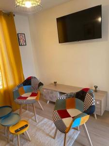 a living room with three chairs and a flat screen tv at Charming Apartment Gacé II 4P in Gacé +1 photo