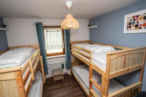a room with two bunk beds and a chandelier at La casa di Matilde - trilocale vicinissimo alle piste da sci in La Thuile