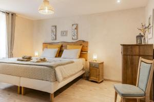 a bedroom with a large bed and a chair at Ysalice in Merlas