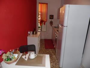 a kitchen with a white refrigerator and a table with a chair at Casa Piazza del Santo in Padova
