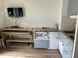 a kitchen with a wooden desk with a computer on it at Mon Appart en Ville in Montpellier