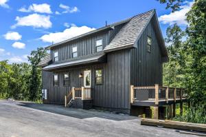 une maison noire avec un toit en gambrel dans l'établissement Pine Ridge Retreat w Hot Tub Grill Games More, à Dandridge