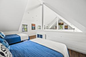 une chambre mansardée avec deux lits et un escalier dans l'établissement Pine Ridge Retreat w Hot Tub Grill Games More, à Dandridge