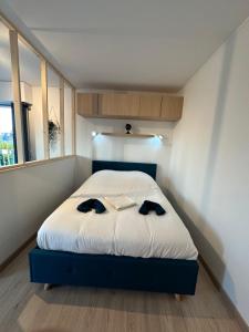 a bedroom with a bed with two black shoes on it at Joli studio Vernon Giverny in Vernon