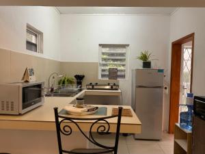 eine Küche mit einem Tisch und einem Kühlschrank in der Unterkunft Tusti in Curepipe