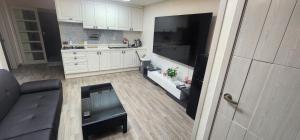 a kitchen with white cabinets and a couch in a room at 3 bedroom apartments in Incheon +2 photos