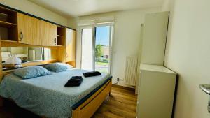 una camera con letto e frigorifero di Villa 5 chambres entre mer et forêt a Merlimont-Plage