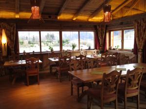 a restaurant with wooden tables and chairs and windows at Zeller Hof in Ruhpolding
