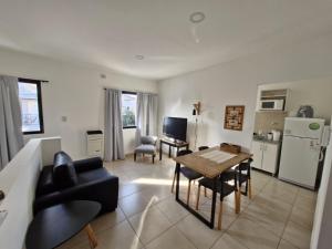 a kitchen and living room with a table and chairs at Apart Origenes in Villa Regina
