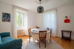 a dining room with a table and a blue couch at Maison Neuve, Grand jardin, Parking privé, Idéal groupe et famille in Marmoutier +56 photos