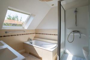 a bathroom with a bath tub and a window at Maison Neuve, Grand jardin, Parking privé, Idéal groupe et famille in Marmoutier