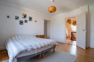 a white bedroom with a bed and a hallway at Maison Neuve, Grand jardin, Parking privé, Idéal groupe et famille in Marmoutier