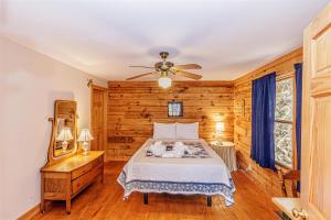 a bedroom with a bed and a ceiling fan at Hummingbird Hollow in Bryson City