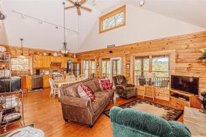 a living room with a couch and a tv at Hummingbird Hollow in Bryson City