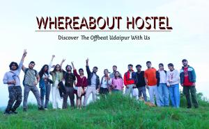 a group of people standing on a hill with their hands in the air at Whereabout Hostel Udaipur in Udaipur