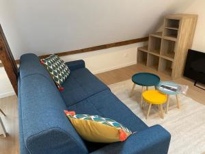 a living room with a blue couch and a table at Charming Apartment Gacé III 4P in Gacé
