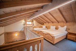 two beds in a room with wooden ceilings at Appartamenti Anna in Livigno