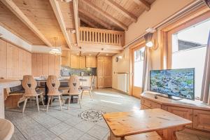 a large kitchen with wooden ceilings and a table and chairs at Appartamenti Anna in Livigno