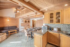 a kitchen with wooden cabinets and a table in a room at Appartamenti Anna in Livigno