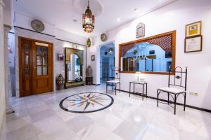 a room with two chairs and a clock on the floor at Hotel Los Omeyas in Córdoba