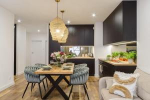 a kitchen and dining room with a table and chairs at Lumina I Premium 3-room Apartments with Parking I Balcony I Manufaktura in Łódź